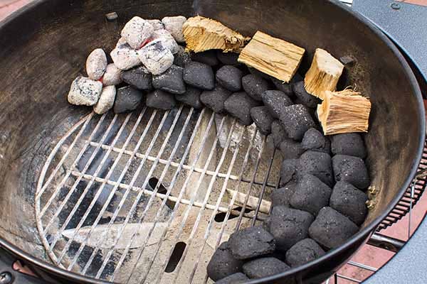 Crescent stacked charcoal briquettes with wood on top lit from one side - Smoked Tri-Tip Beef - Grilling Inspiration